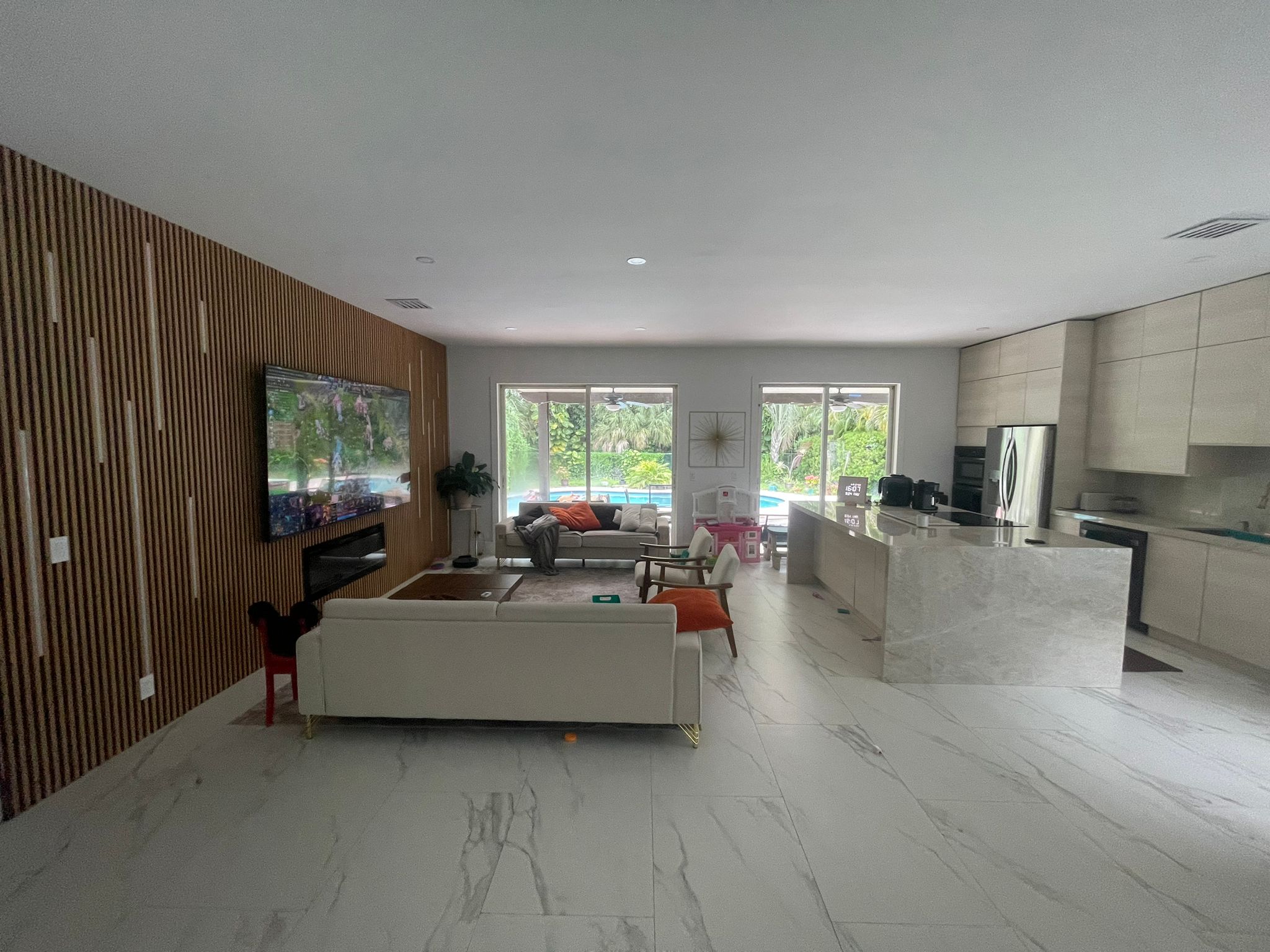 Coral Springs open living area with wood feature wall and light flooring