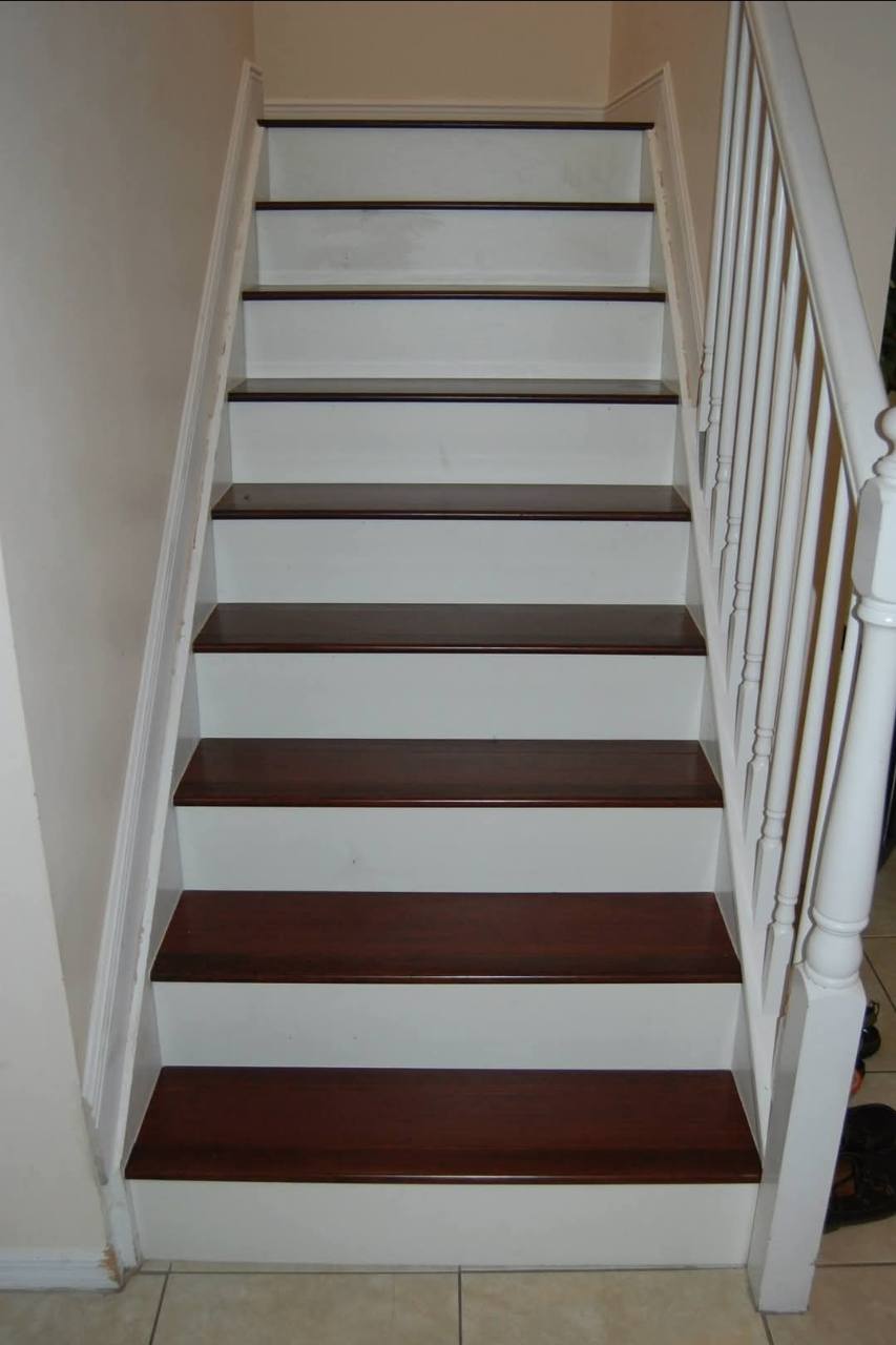 Dark stair treads with white risers and a white railing