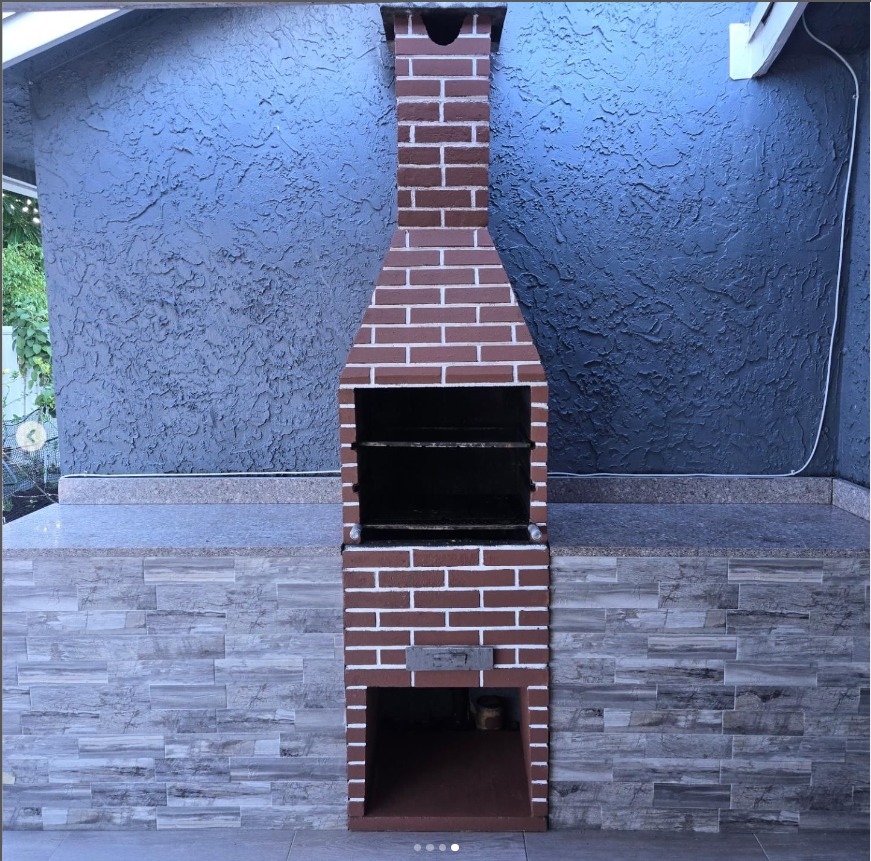 Completed brick outdoor barbecue with stone counters and tiled cabinet faces from VMA's project portfolio