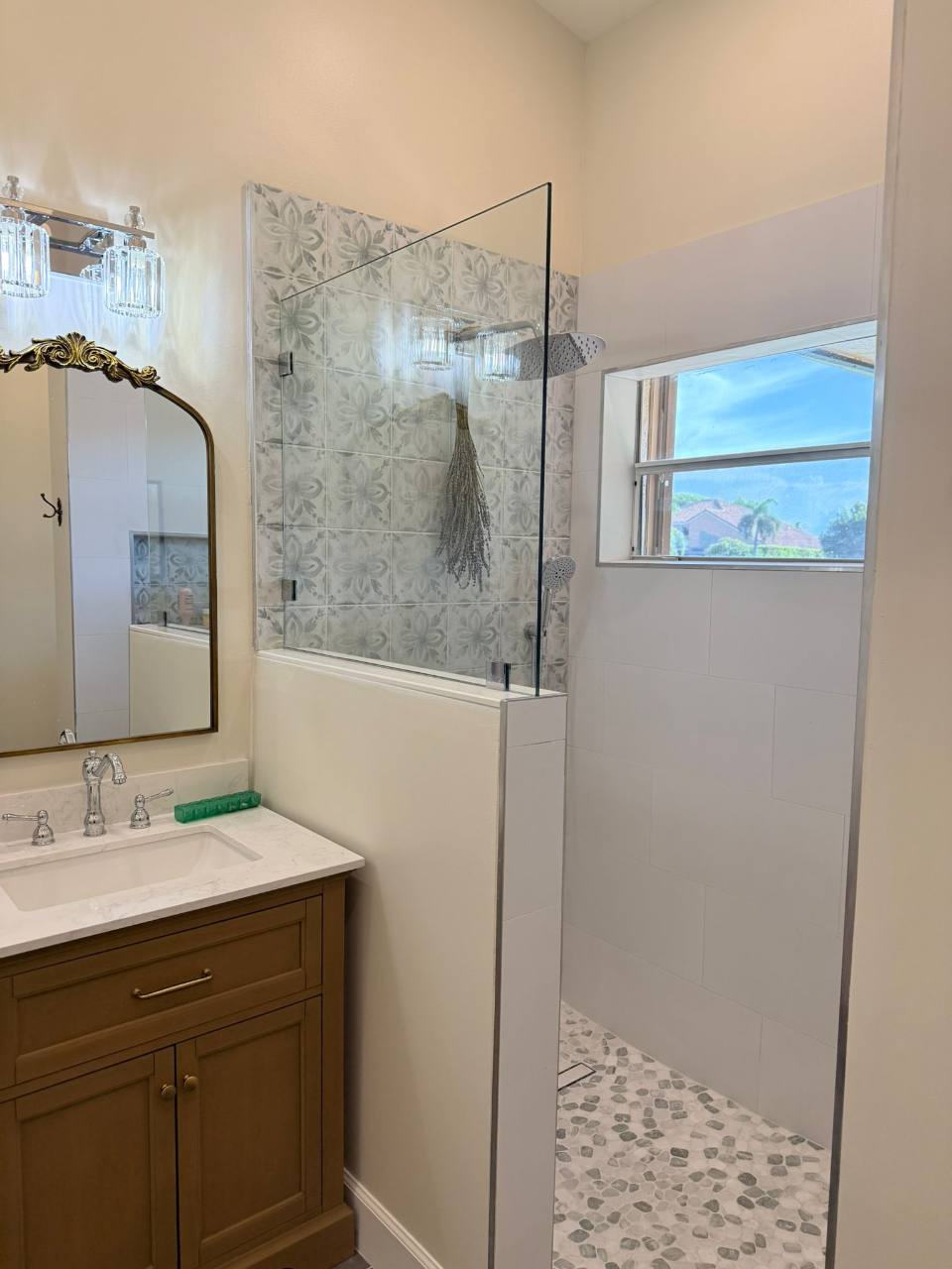 Patterned shower tile, a glass screen, and a warm-toned vanity