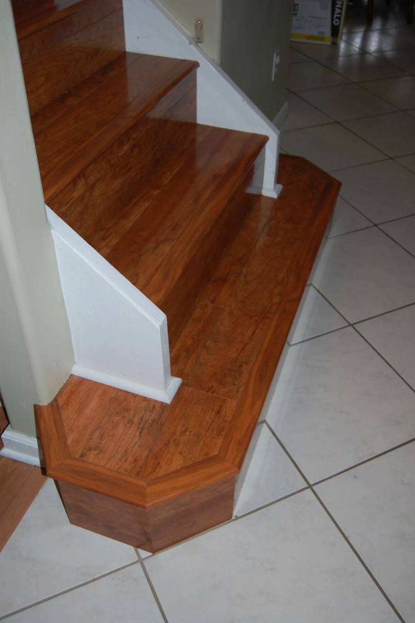 Warm-toned stair finish wrapping around an angled base