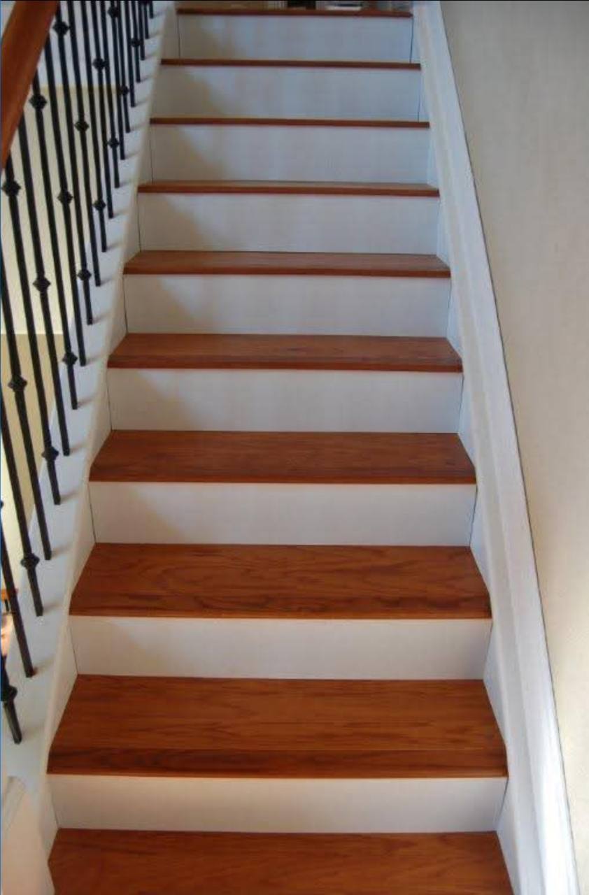 Warm-toned stair treads with white risers and dark balusters